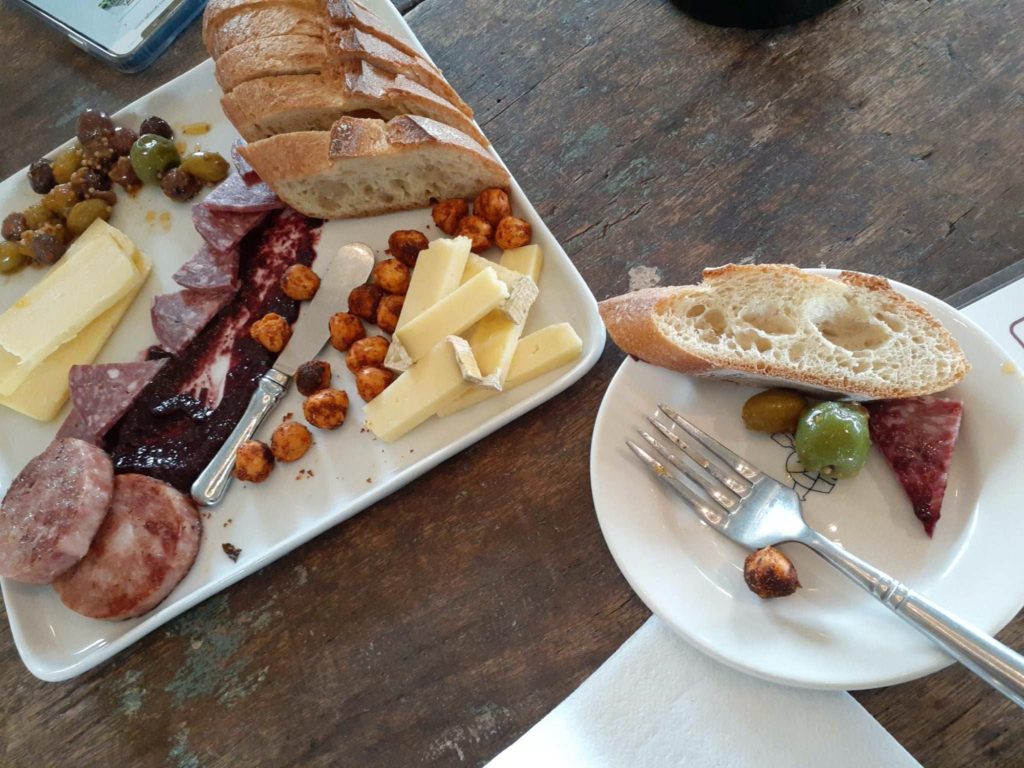 A plate of small bites that can be paired with your wine flight at Brooks Wine - olives, cheese, bread and more